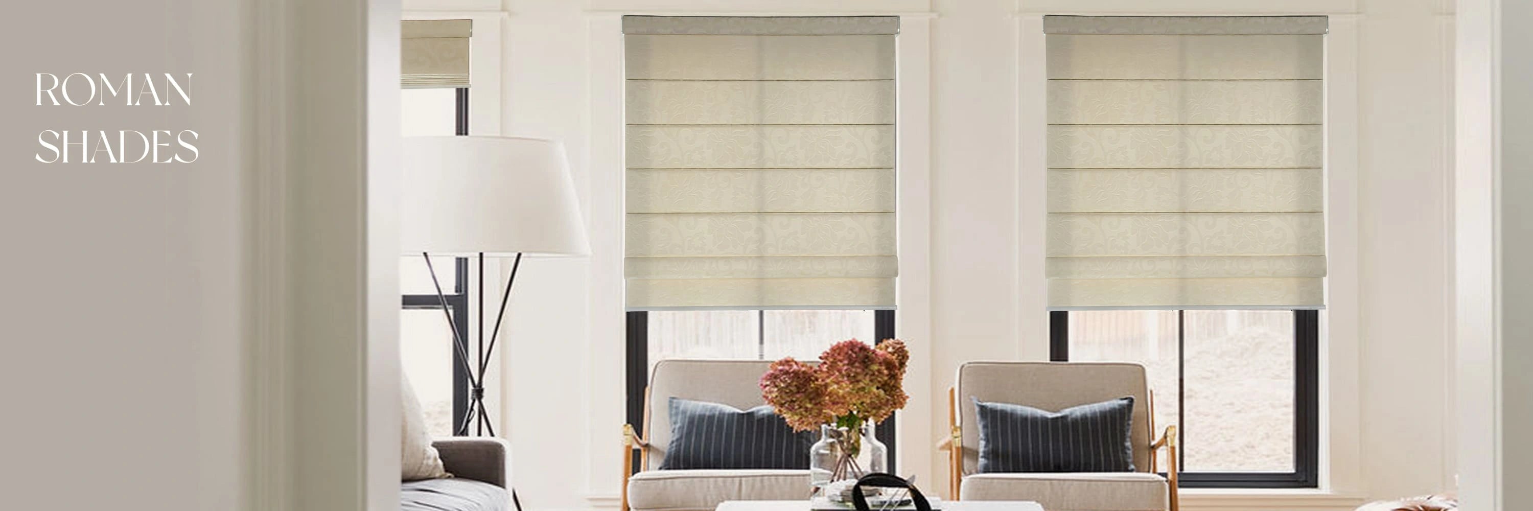 Living room with beige Roman shades on windows, sofa, and decorative elements.