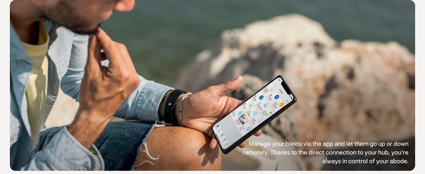 A man controls smart cellular shades through his smartphone