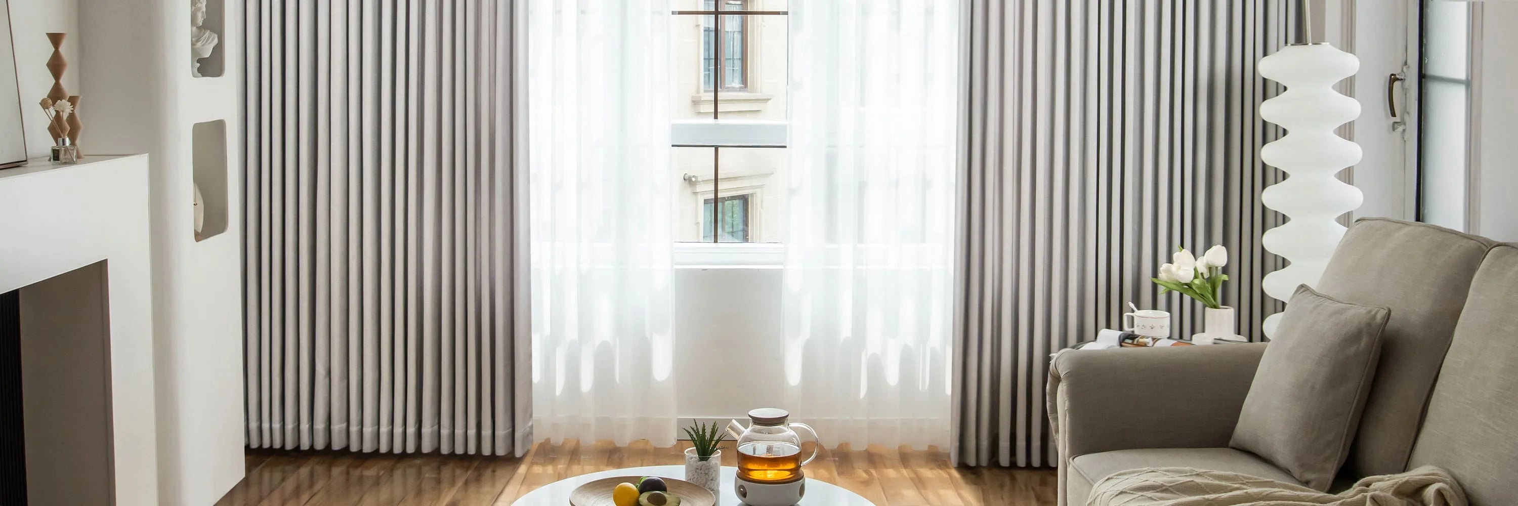 Living room with doulbe-layerded curtains, a sofa, and a coffee table.
