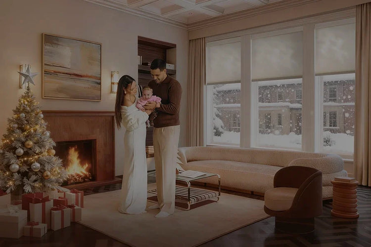 Family in a living room with a Christmas tree, fireplace, and smart blinds.