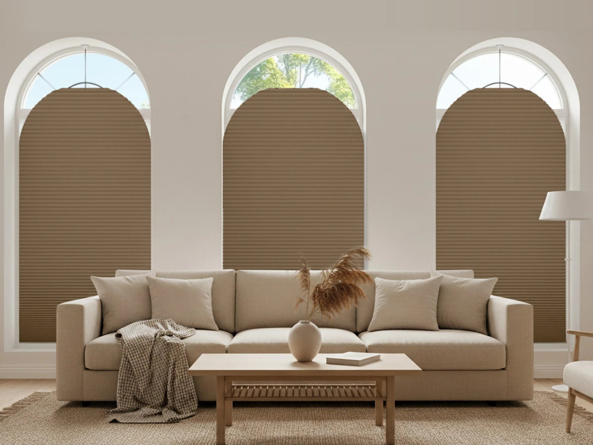 Beige sofa in a living room with arch-shaped windows and brown blinds.