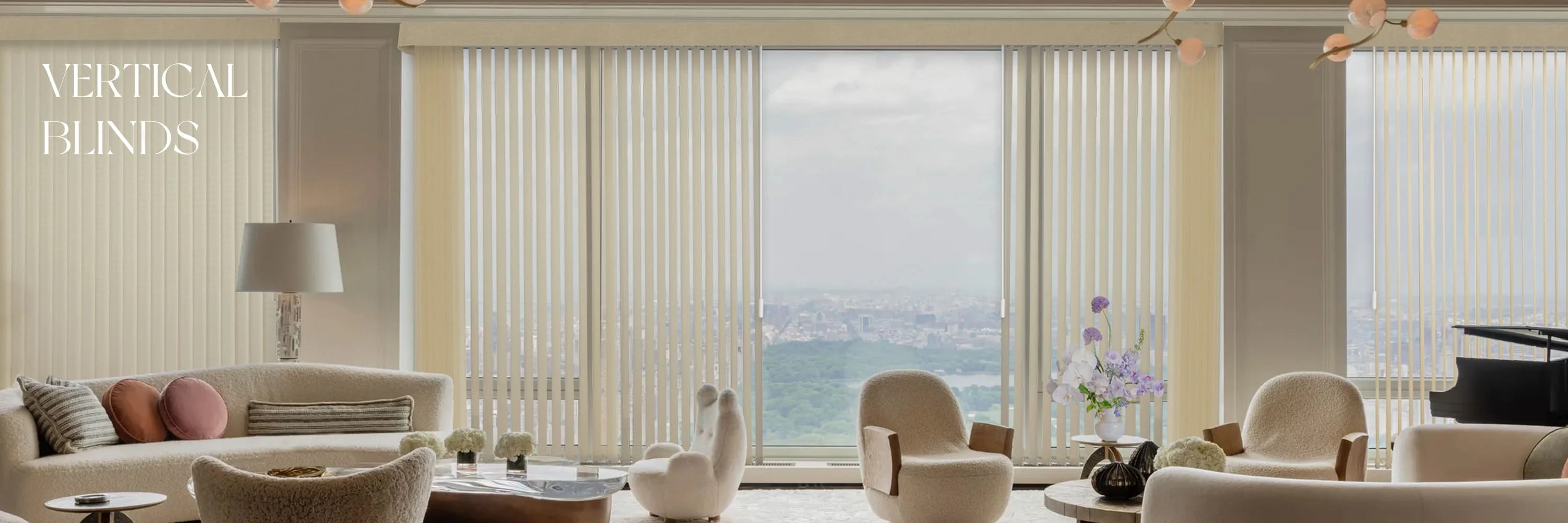 Living room with vertical blinds covering large windows, featuring a sofa and chairs.