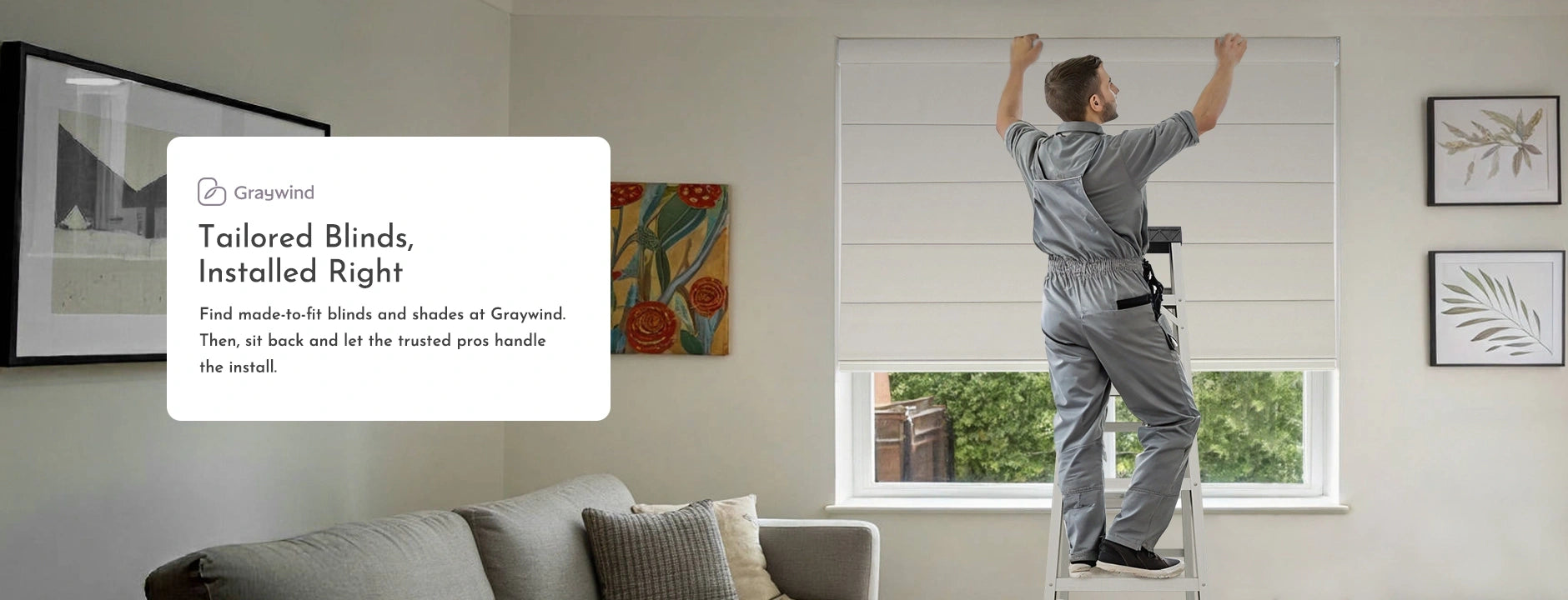 Person installing blinds in a room with a couch and window.