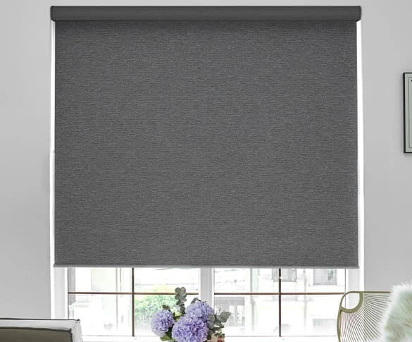 Dark gray roller blind covering a window with a light background