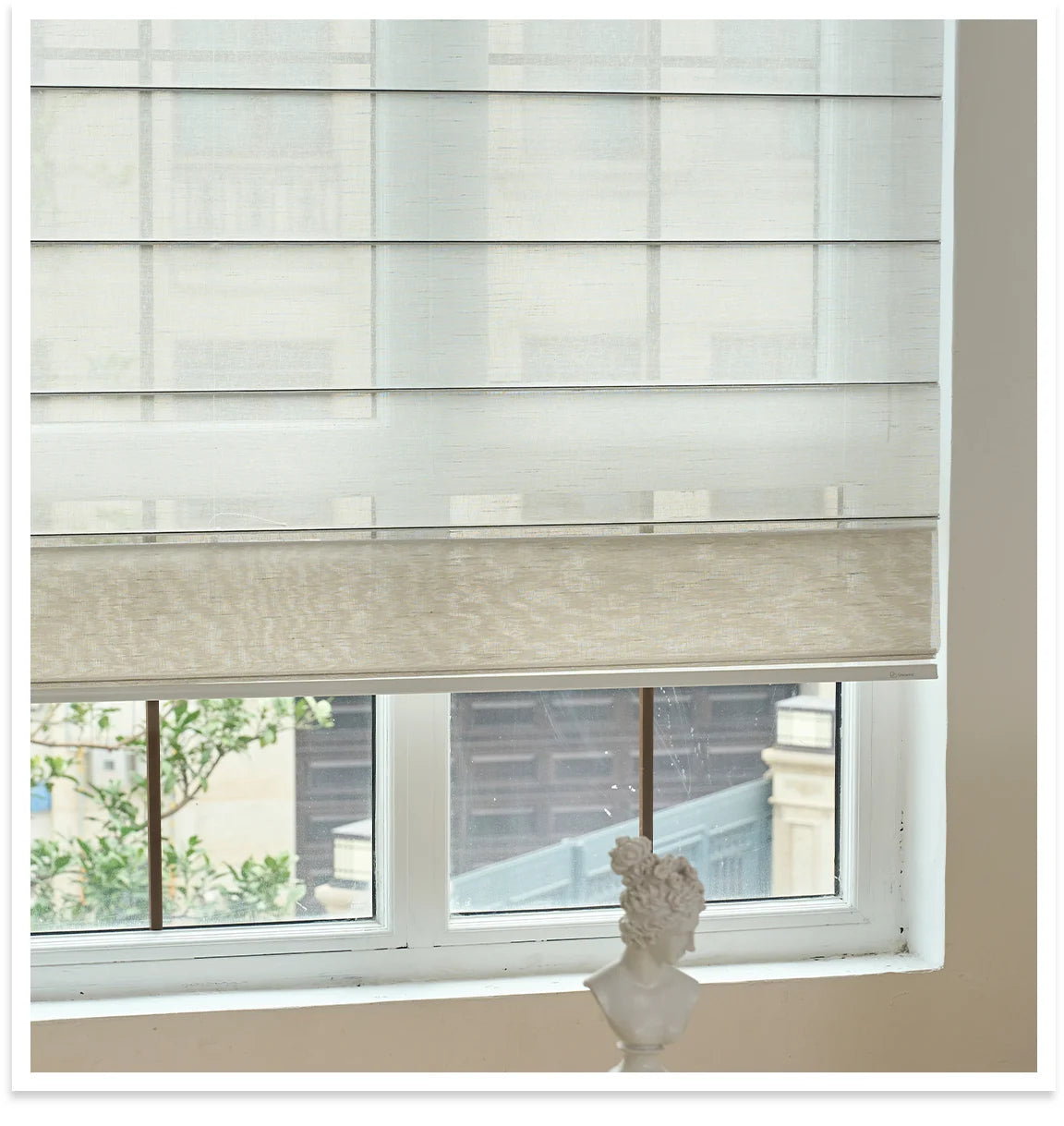 Window with roman blinds and a decorative shell on a windowsill.
