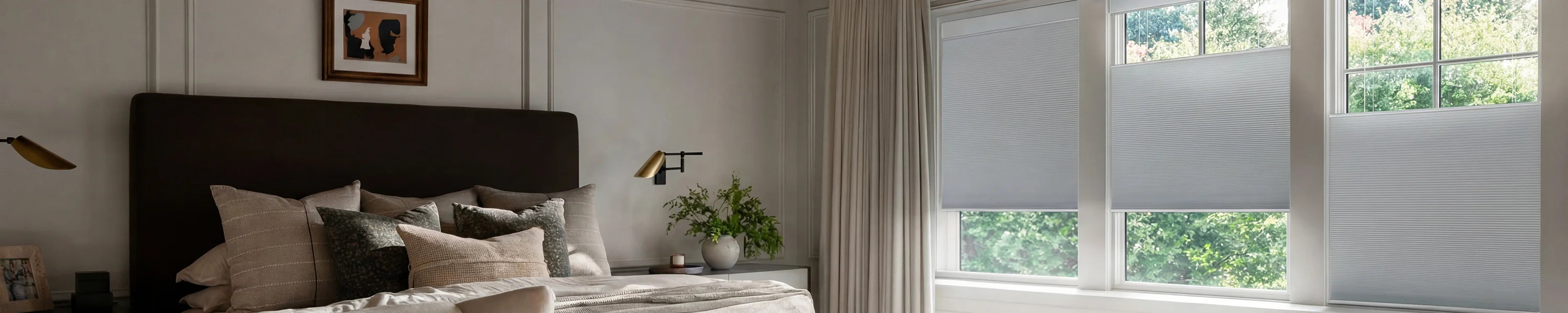 Modern bedroom with a bed, pillows, and a window with top down bottom up blinds.